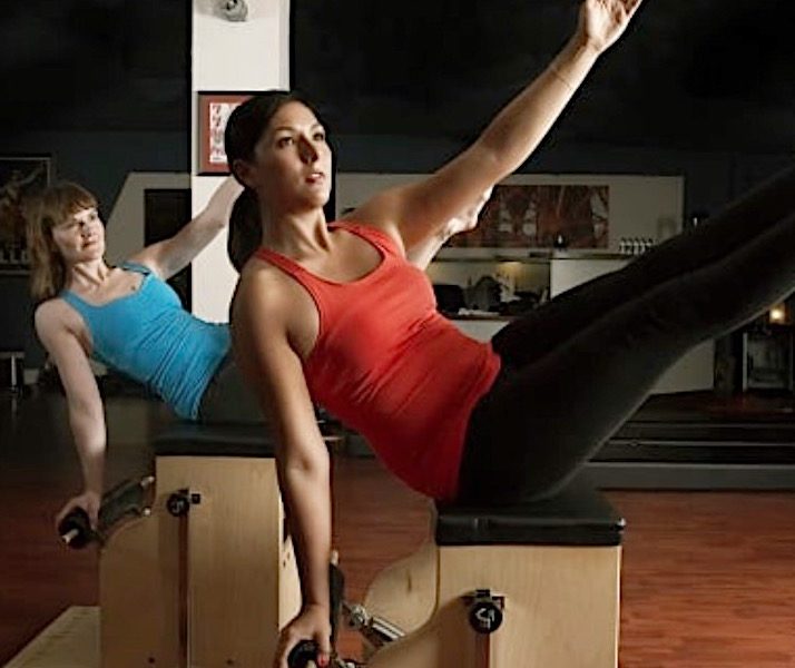two women on pilates reformer working out