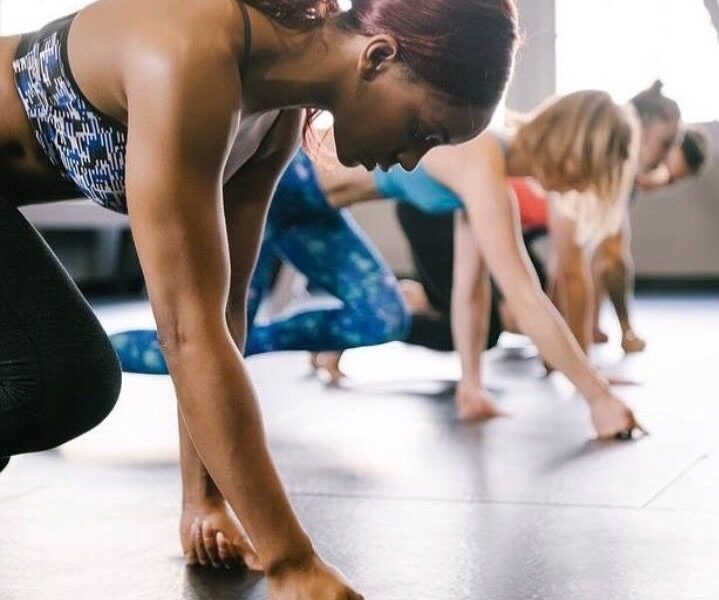 woman working out in a room full of other women working out
