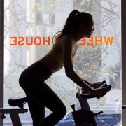woman's silhouette on a spin bike near a window