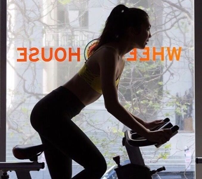 woman's silhouette on a spin bike near a window