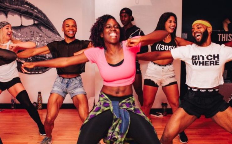 woman in pink crop top dancing with a big smile