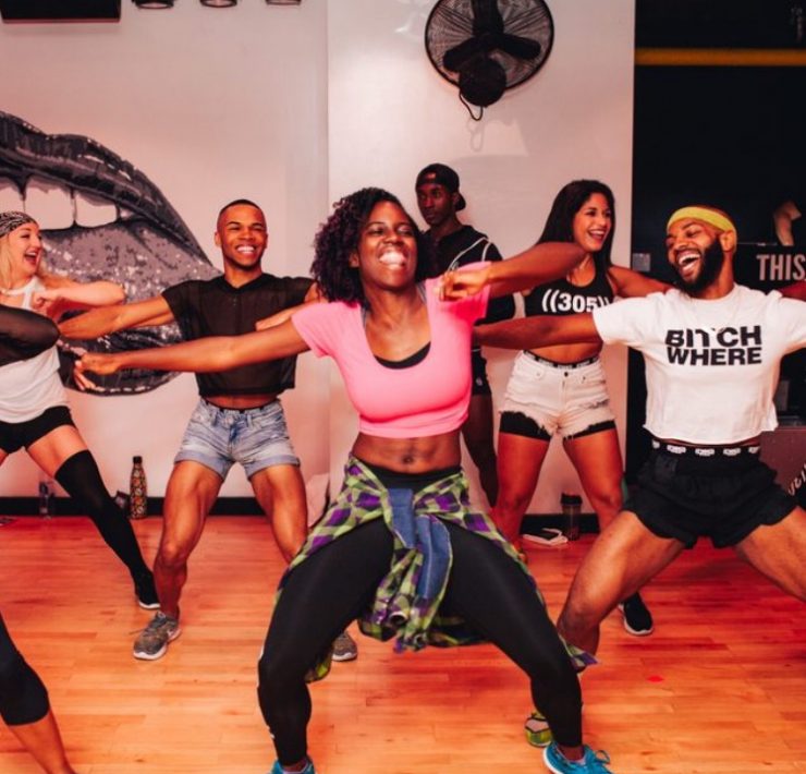 woman in pink crop top dancing with a big smile