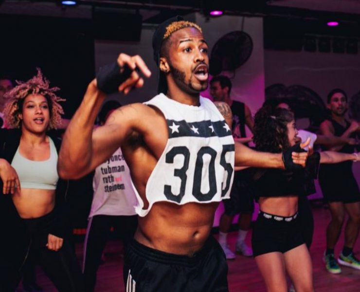 man dancing in white crop top and black pants