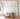 Interior of a yoga studio lobby. All white, wooden floors, brown couch and a large hanging crystal.